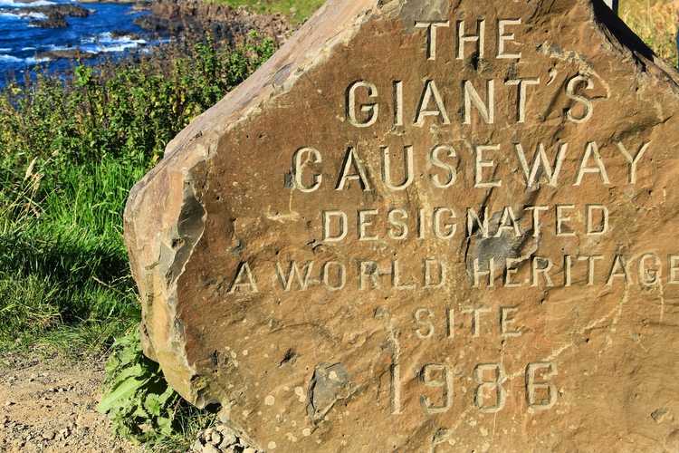 Close-up view of the historic carved stone marking the Giant's Causeway as an official UNESCO World Heritage Site since 1986